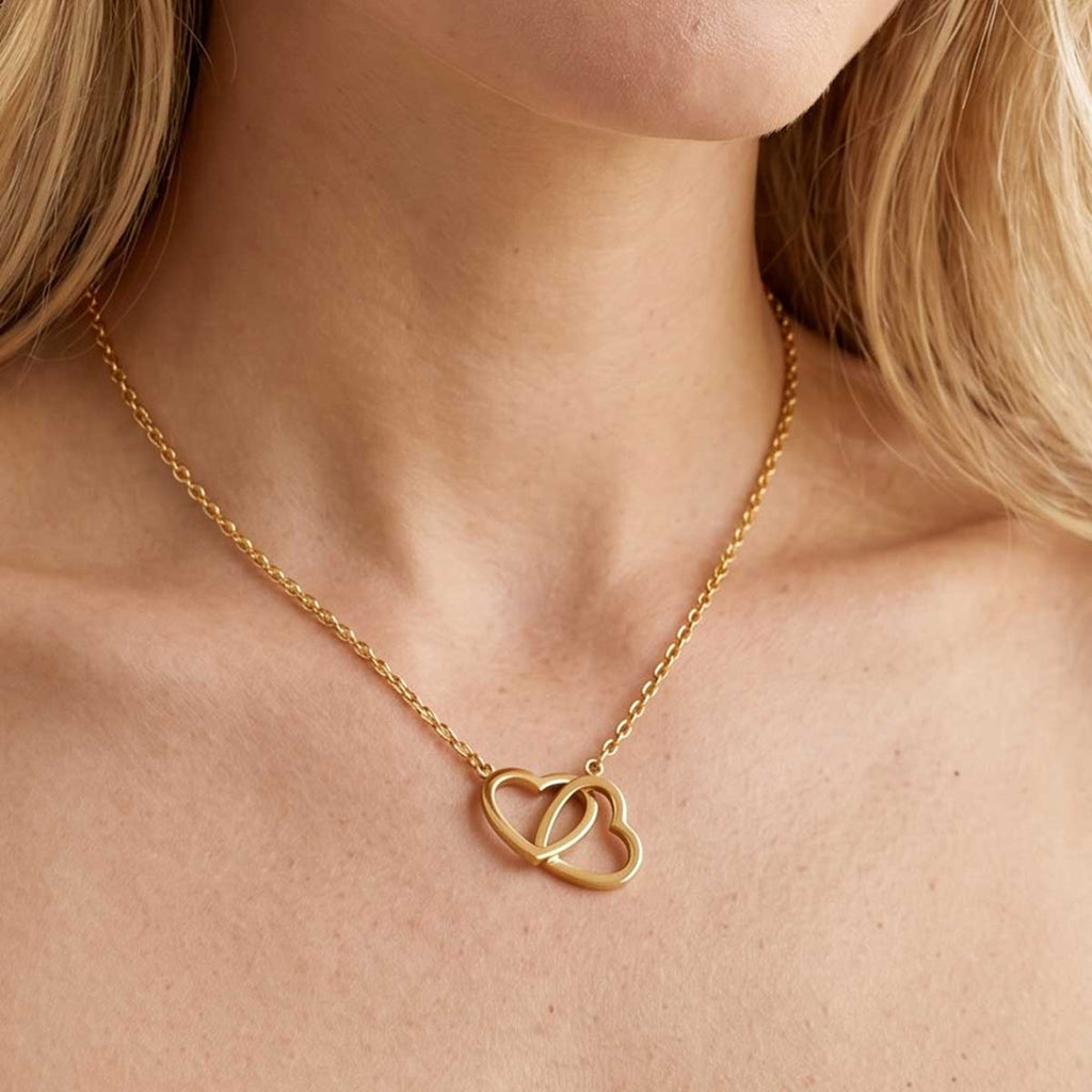 Goldfarbene Damen Halskette mit Herzen Anhänger am Hals eines Models getragen.