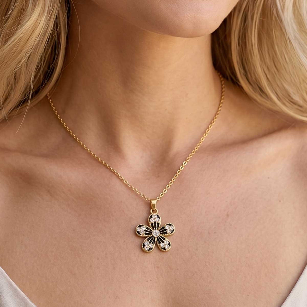 Goldfarbene Damen Halskette mit Blumen Anhänger am Hals eines Models getragen.