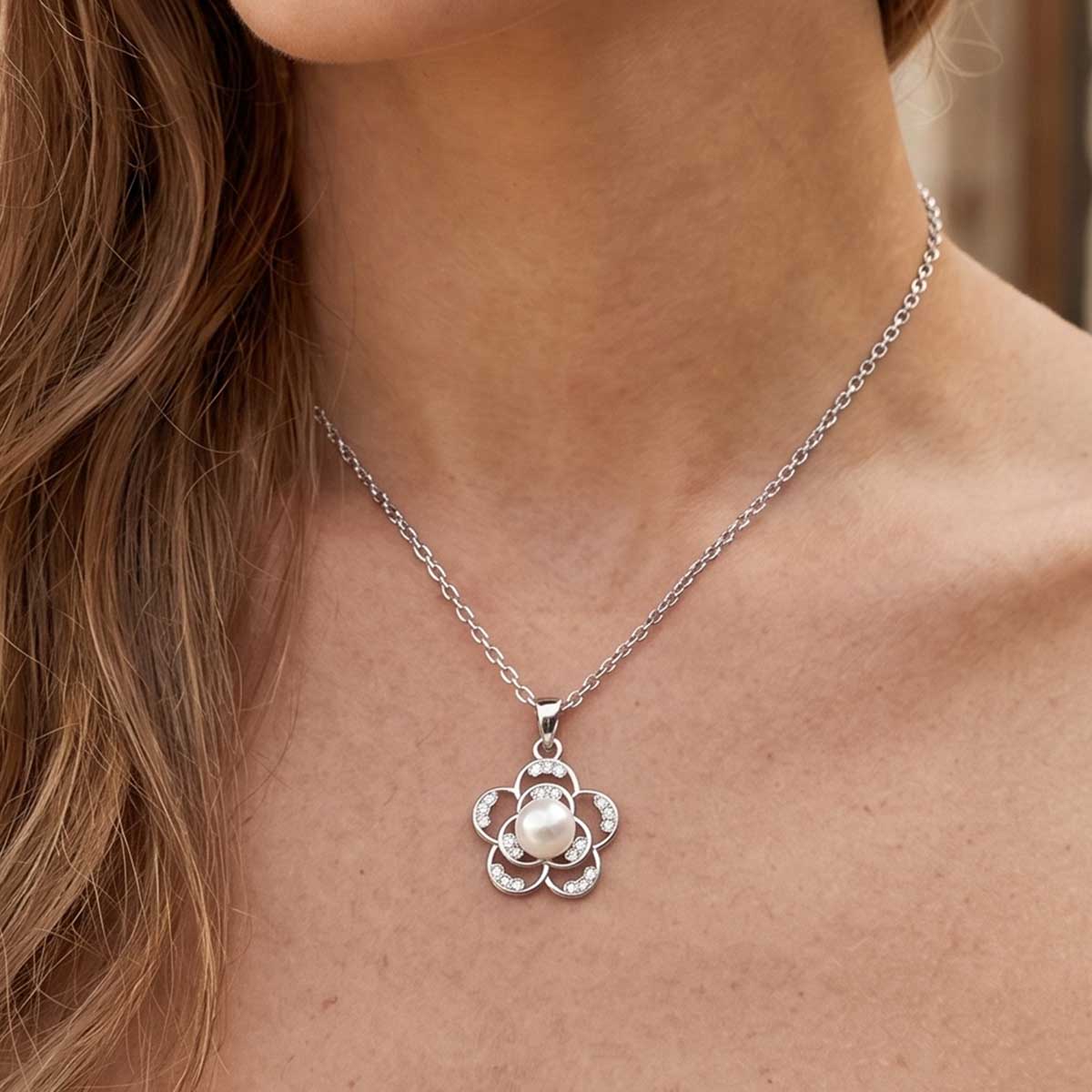 Silberfarbene Damen Halskette mit Blüten Anhänger am Hals eines Models getragen.