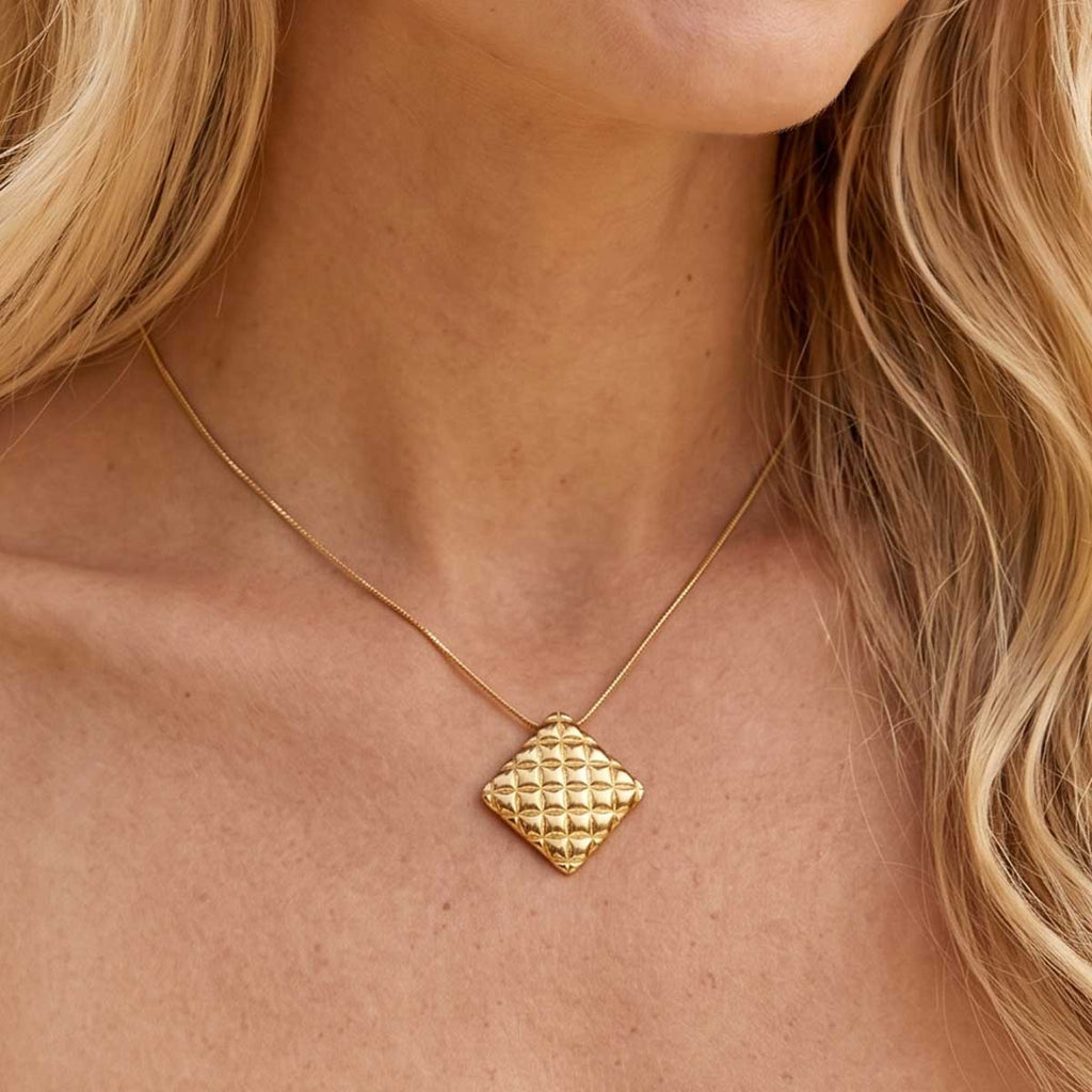 Goldfarbene Damen Halskette mit Kissen Anhänger am Hals eines Models getragen.