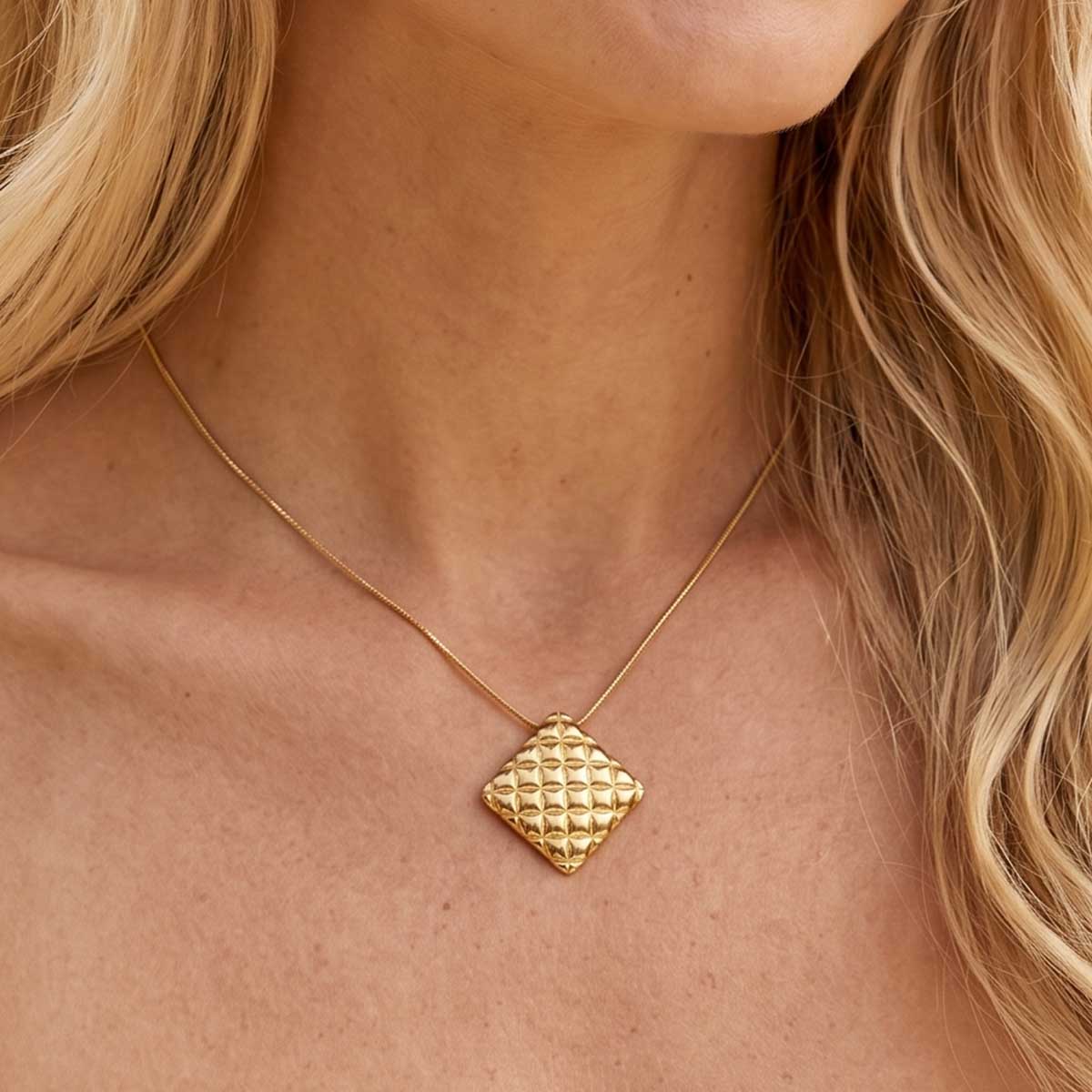 Goldfarbene Damen Halskette mit Kissen Anhänger am Hals eines Models getragen.