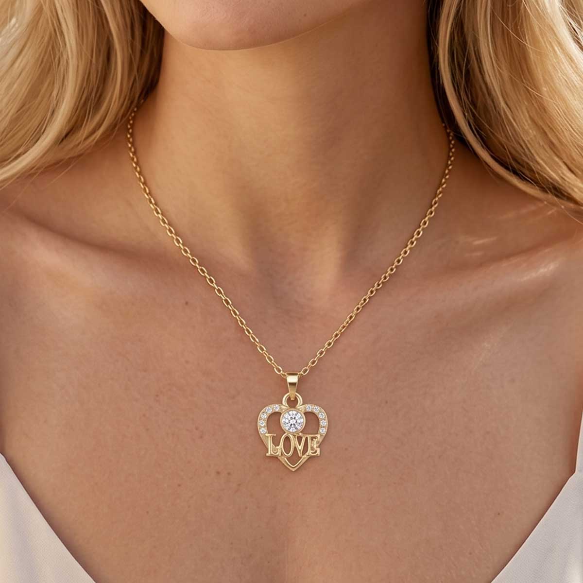 Goldfarbene Damen Halskette mit Herz Anhänger am Hals eines Models getragen.