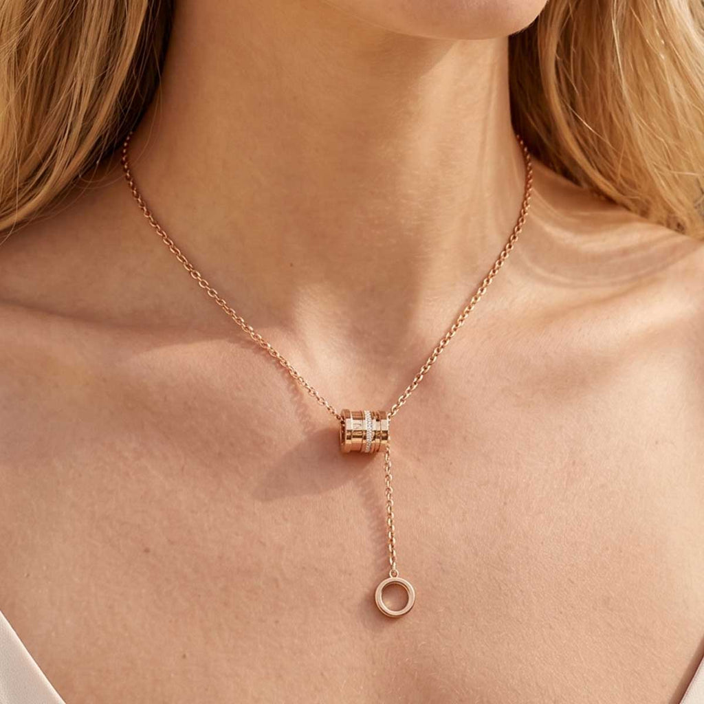Rosegoldfarbene Y Halskette mit Anhänger am Hals eines Models getragen.