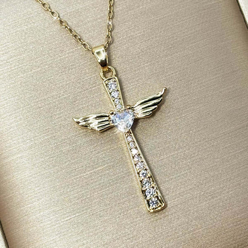 Damen Halskette mit einem eleganten Kreuz-Anhänger, besetzt mit Zirkonia-Steinen, seitlichen Engelsflügeln und einem zentralen Zirkonia-Herz, Nahaufnahme von links.