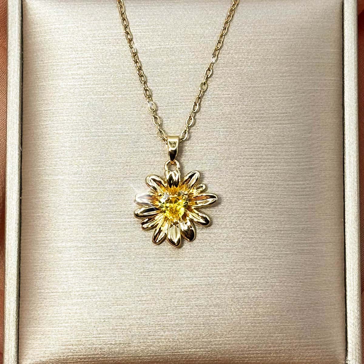 Damen Halskette mit detailreichem Sonnenblumen-Anhänger und einem leuchtend gelben Zirkonia-Stein im Zentrum, Studio-Produktfoto.