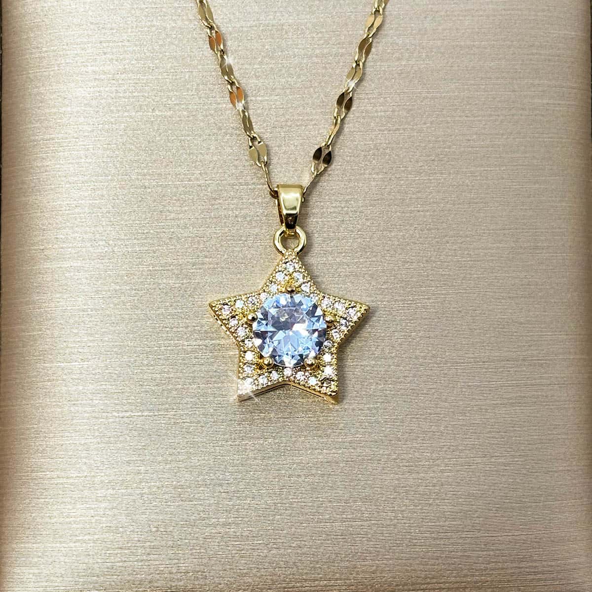 Damen Halskette mit fünfzackigem Stern-Anhänger, einem großen hellblauen Zirkonia-Stein im Zentrum und kleiner Umrandung, Nahaufnahme.