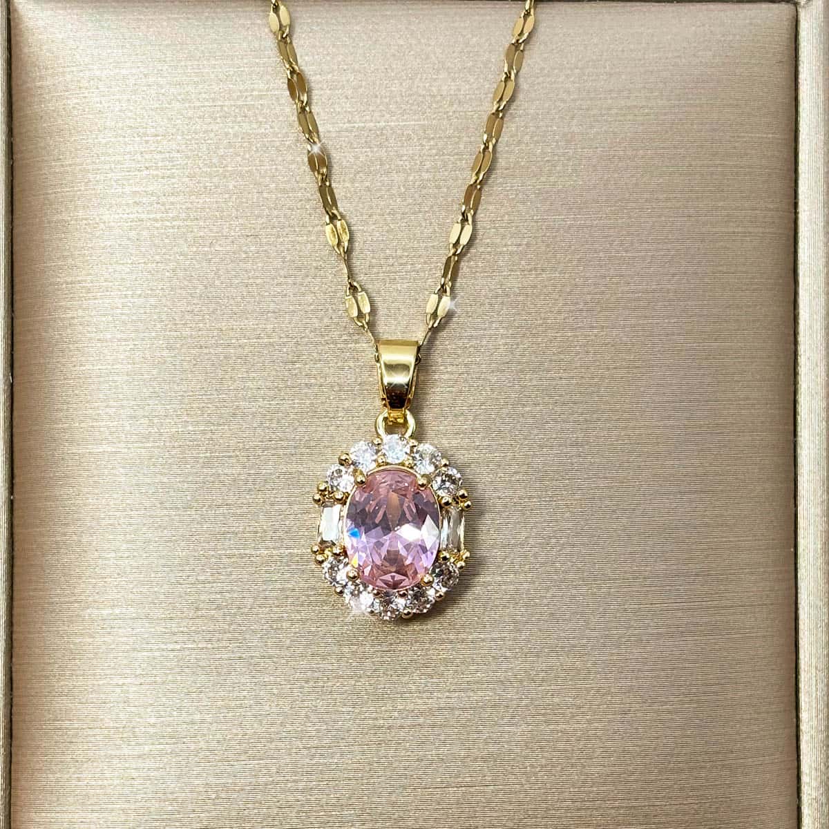 Halskette mit ovalem Anhänger, besetzt mit einem großen rosa Zirkonia-Stein und einem Kranz aus klaren Steinen, Produktfoto.