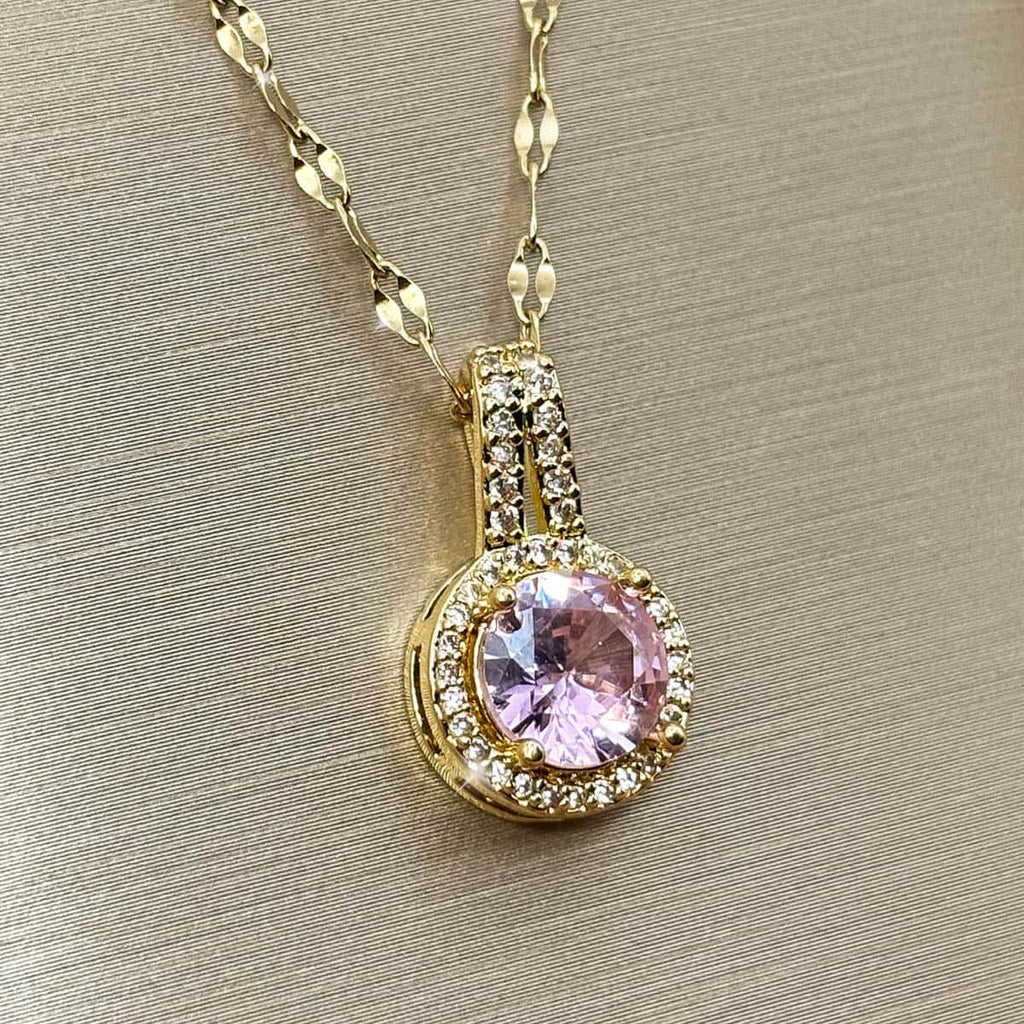 Halskette mit kreisrundem Anhänger, einem großen rosa Zirkonia-Stein im Zentrum und kleiner Zirkonia-Umrandung, Nahaufnahme von links