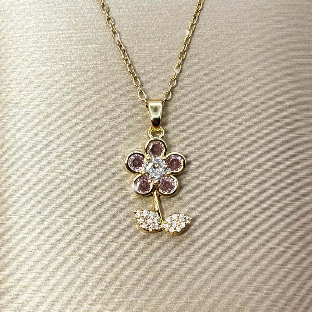 Halskette mit Blumen-Anhänger, besetzt mit rosa und weißen Zirkonia-Steinen, Nahaufnahme der Vorderseite.