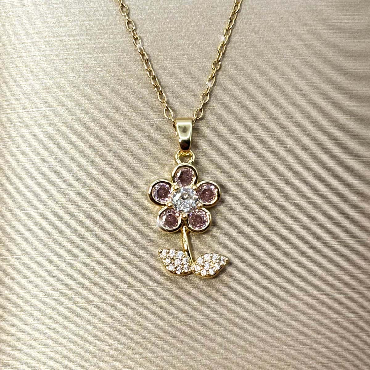 Halskette mit Blumen-Anhänger, besetzt mit rosa und weißen Zirkonia-Steinen, Nahaufnahme der Vorderseite.