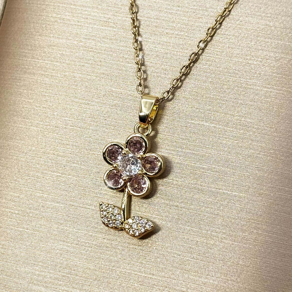 Halskette mit Blumen-Anhänger, besetzt mit rosa und weißen Zirkonia-Steinen, seitliche Ansicht von rechts.