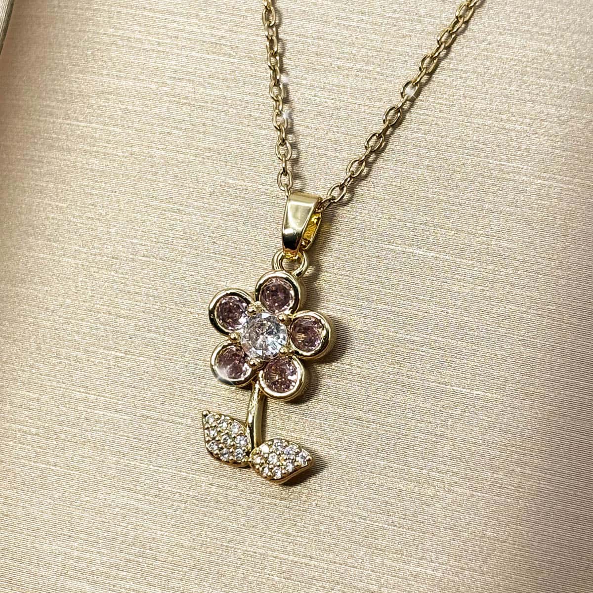 Halskette mit Blumen-Anhänger, besetzt mit rosa und weißen Zirkonia-Steinen, seitliche Ansicht von rechts.