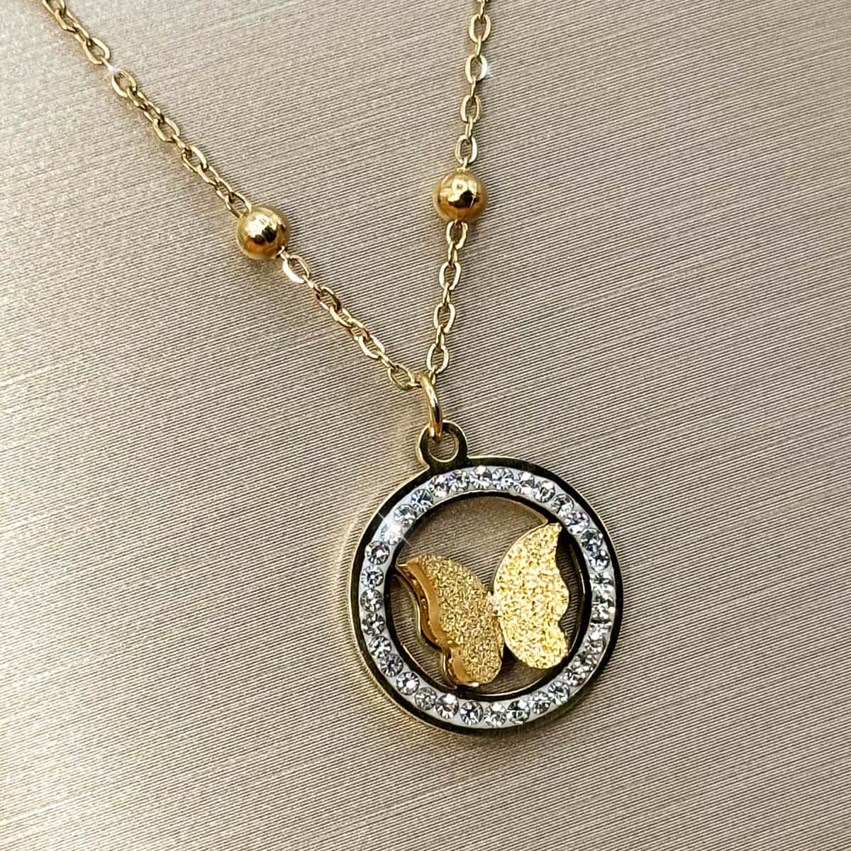 Halskette mit rundem Rahmen-Anhänger, filigranem Schmetterling und glitzerndem Zirkonia-Kranz, Seitenansicht von links.