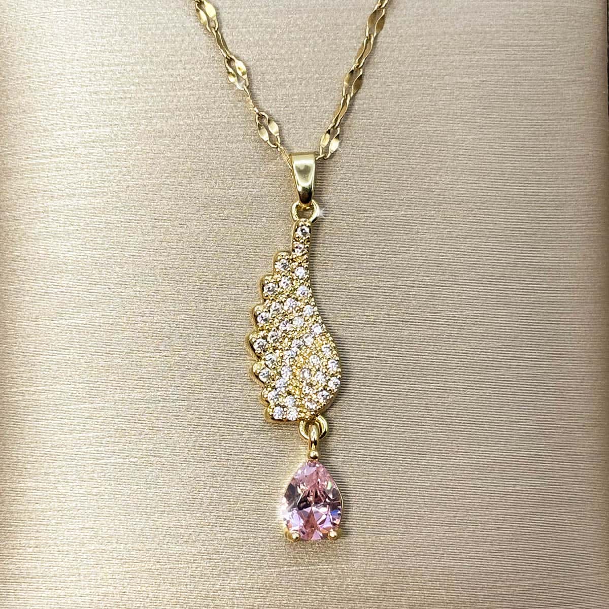 Damen Halskette mit geschwungenem, kristallbesetztem Flügel-Anhänger und rosa Zirkonia-Tropfen, Detail-Aufnahme.