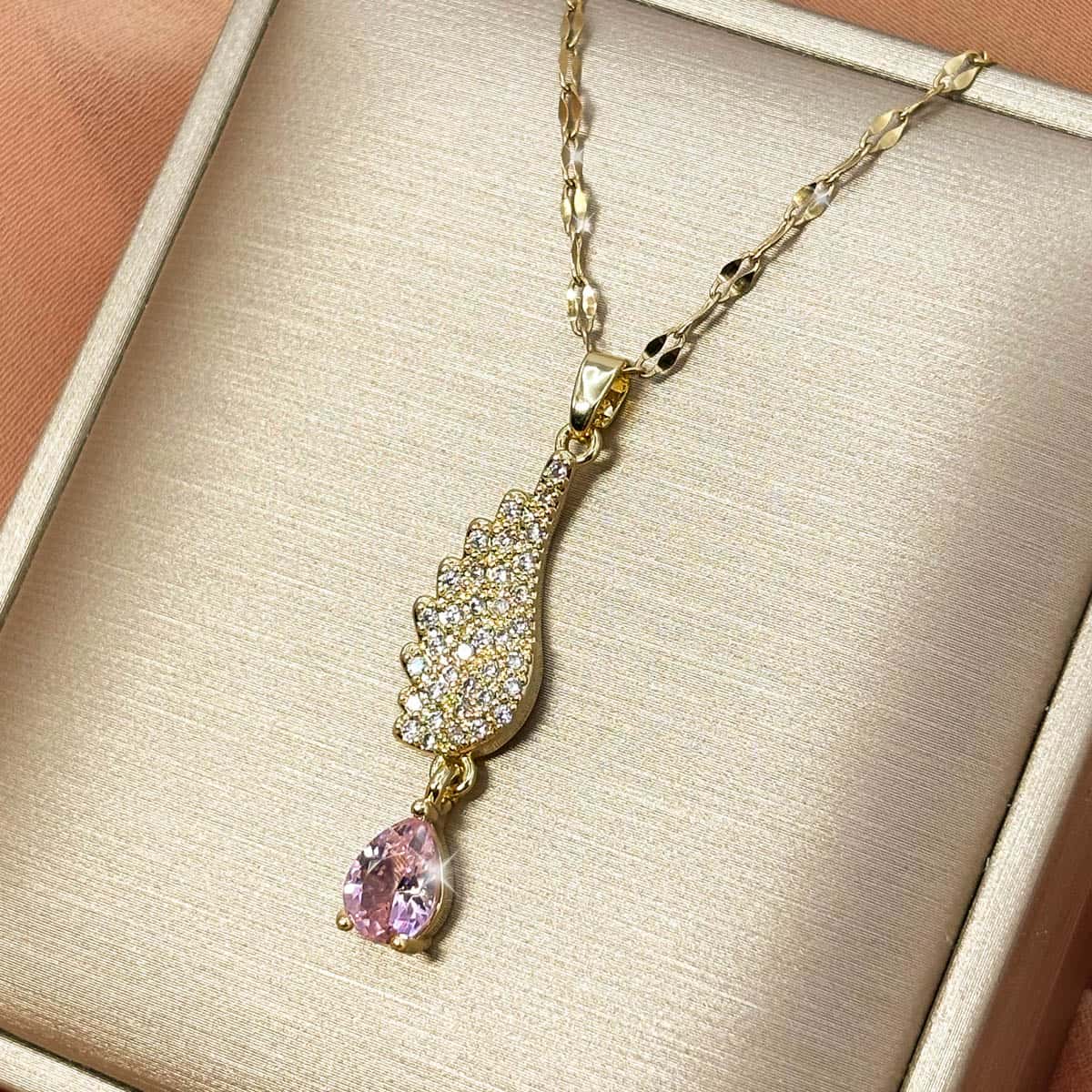 Damen Halskette mit geschwungenem, kristallbesetztem Flügel-Anhänger und rosa Zirkonia-Tropfen, seitliche Ansicht von rechts.