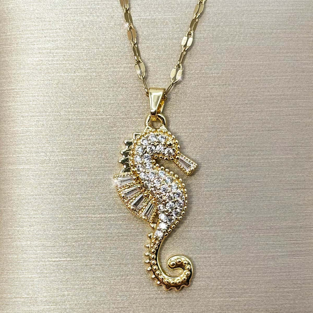 Goldene Damen Kette mit detailreichem Seepferdchen-Anhänger, besetzt mit weißen Zirkonia-Kristallen, Vorderansicht.