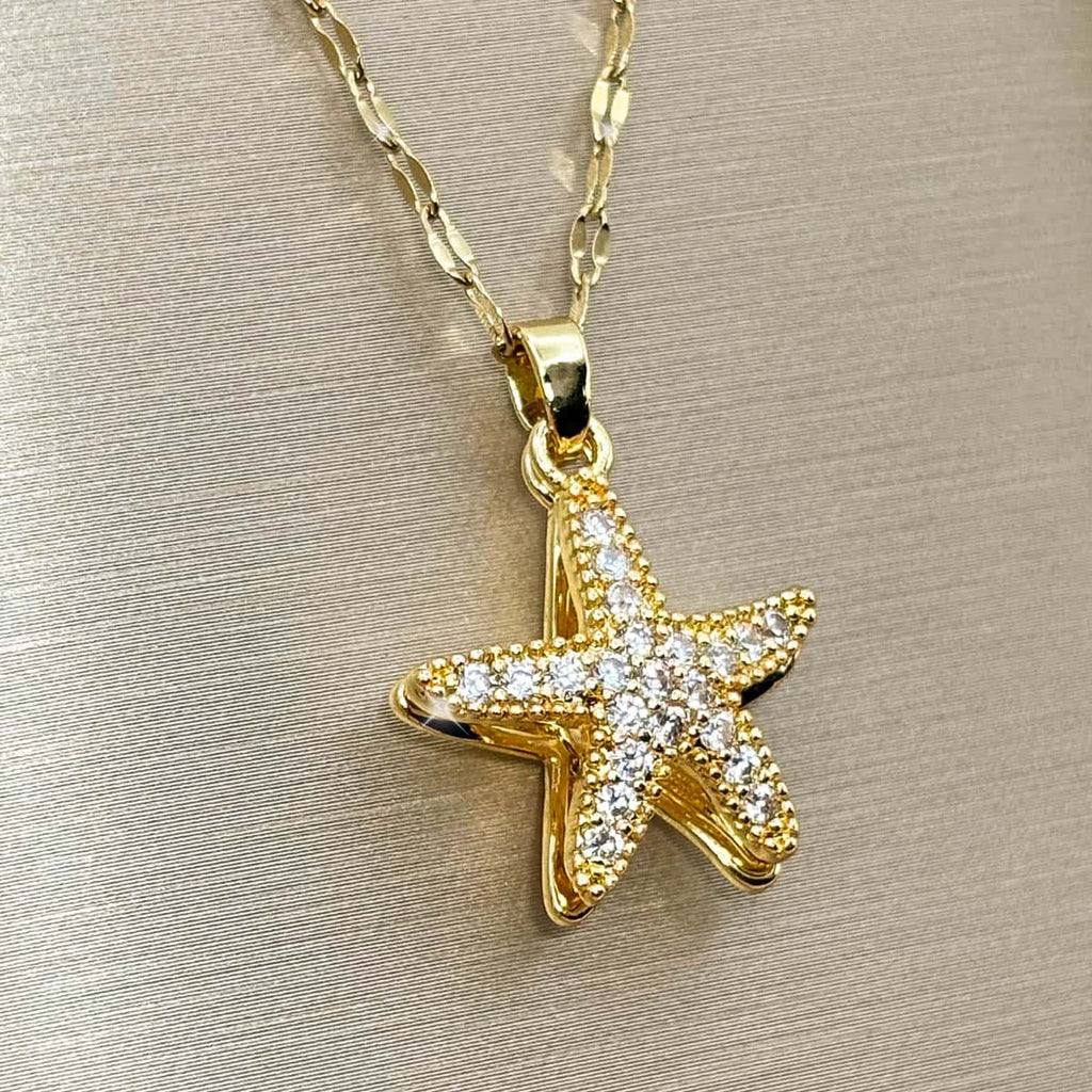 Goldene Halskette mit maritimem Seestern-Anhänger und funkelnden Zirkonia-Steinen, seitliche Ansicht von links.