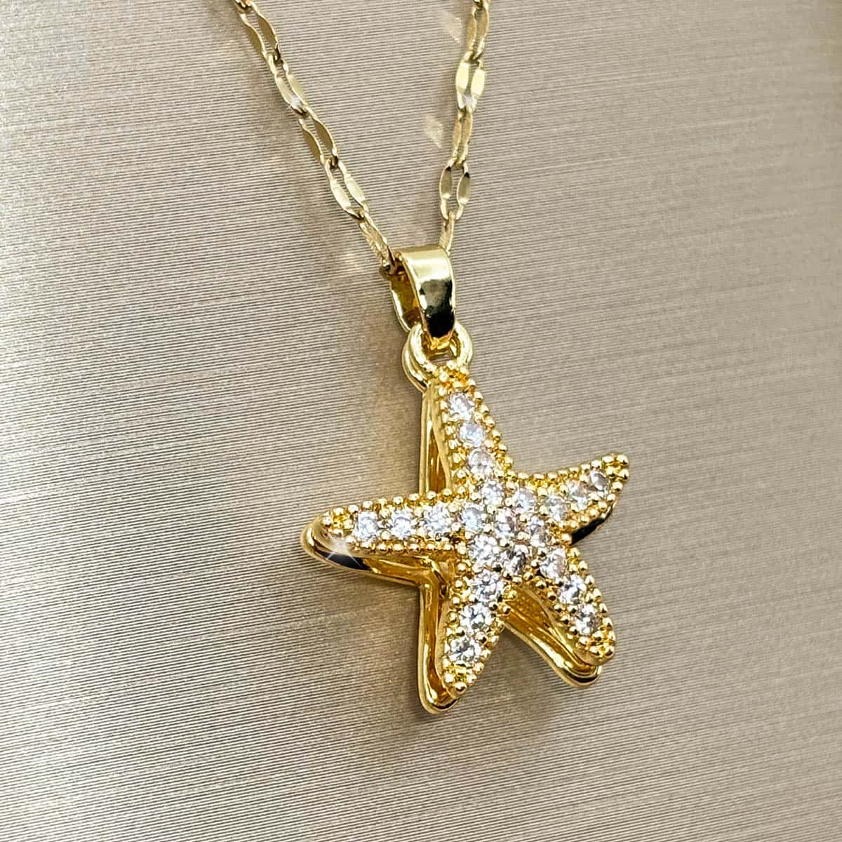 Goldene Halskette mit maritimem Seestern-Anhänger und funkelnden Zirkonia-Steinen, seitliche Ansicht von links.