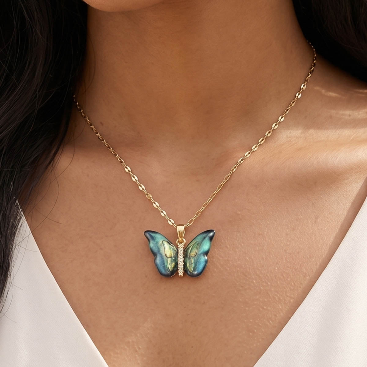 Damen Halskette mit einem indigo Schmetterling Anhänger am Hals eines Models getragen.