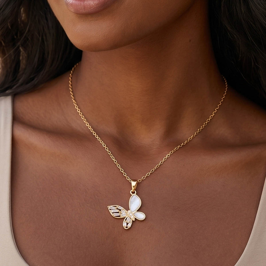 Goldene Edelstahl Damen Halskette mit einem Schmetterling Anhänger am Hals eines Models getragen.