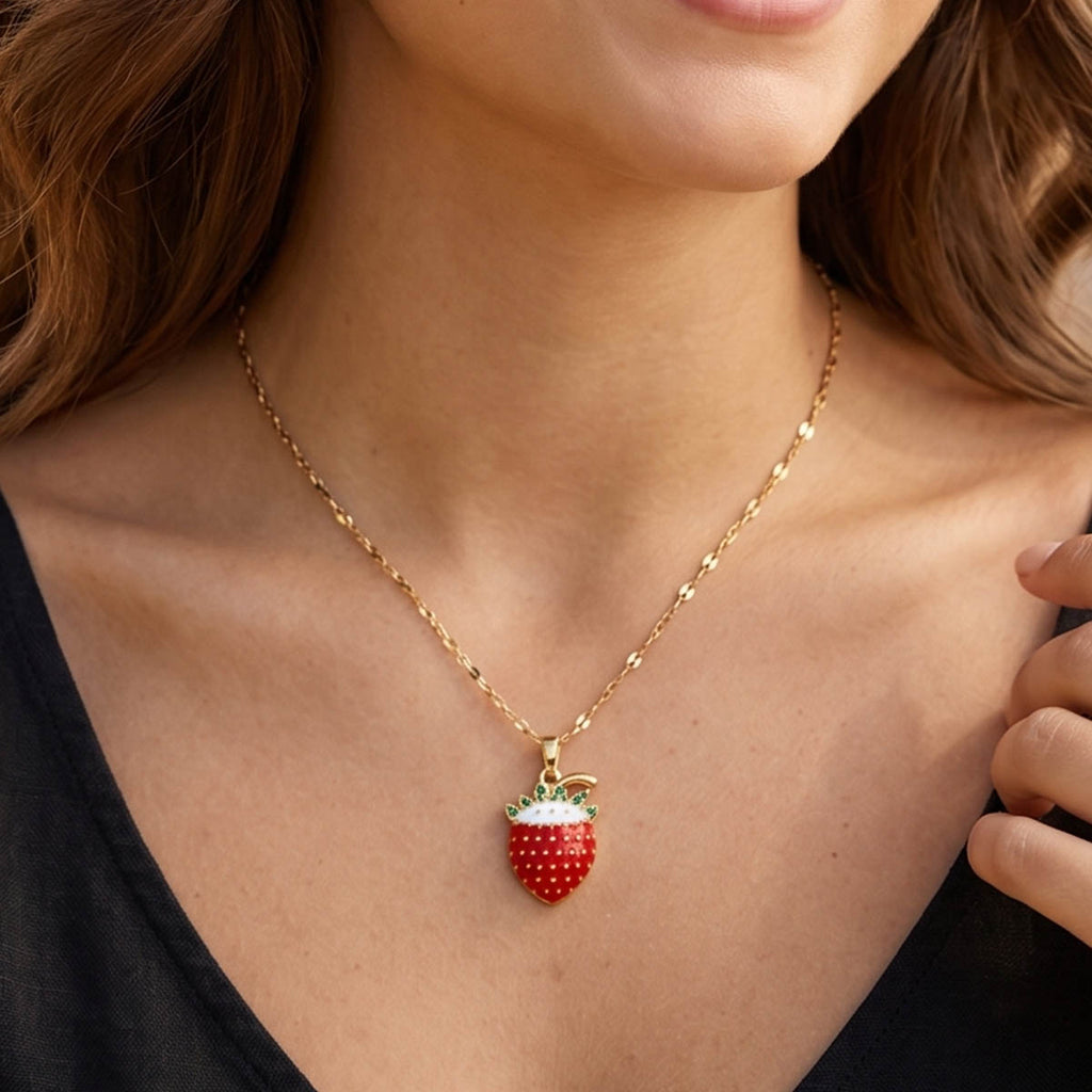 Goldene Edelstahl Halskette mit einem Erdbeeren Anhänger am Hals eines Models getragen.