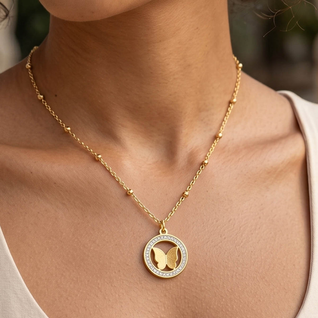 Goldene Edelstahl Halskette mit Schmetterling Anhänger am Hals eines Models getragen.