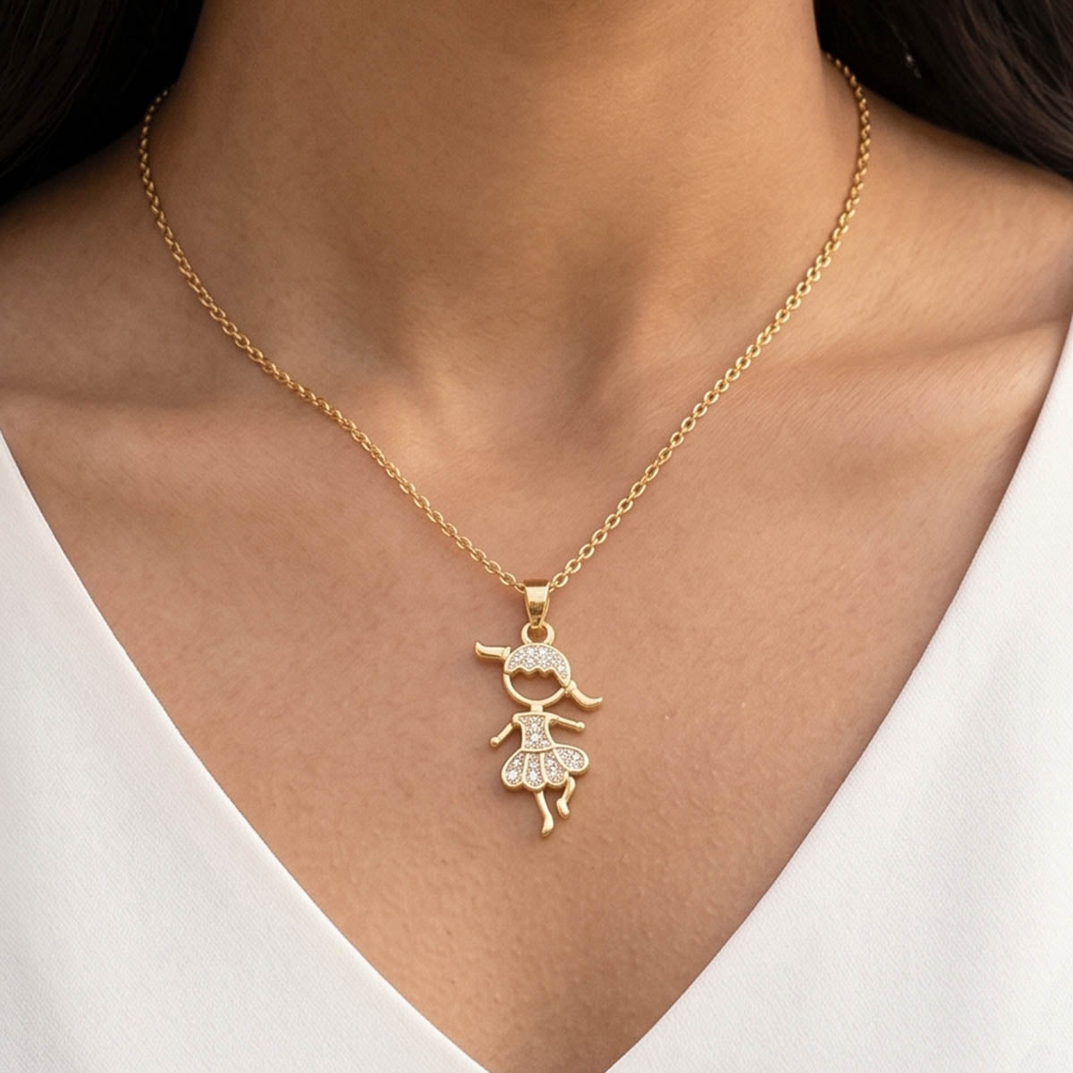 Goldene Edelstahl-Halskette mit Mädchen Anhänger am Hals eines Models getragen.