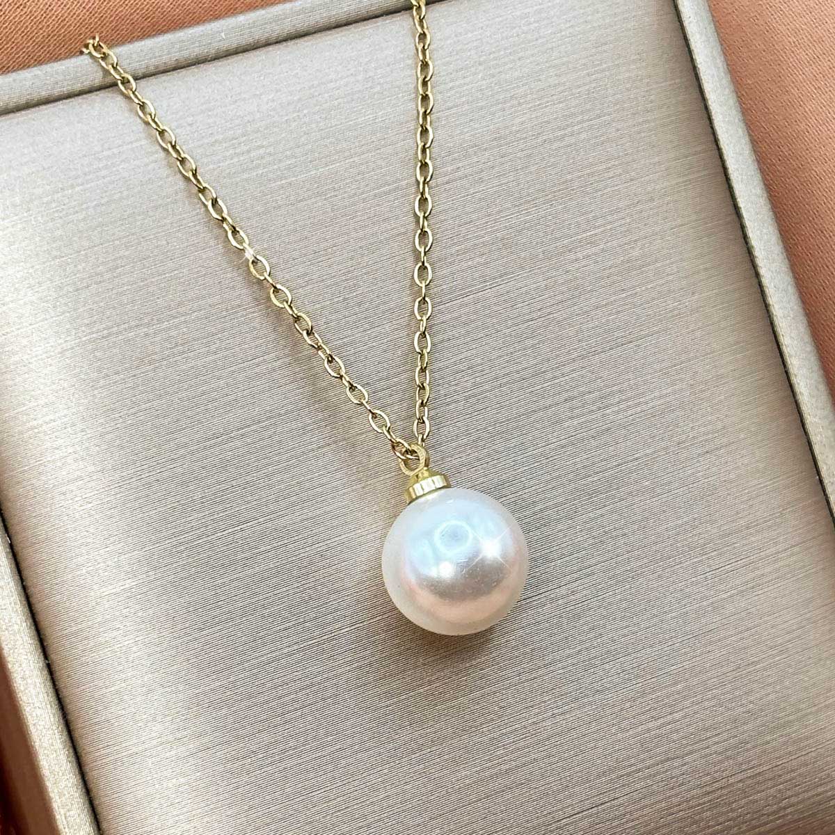 Goldfarbene Edelstahl-Halskette für Damen mit einer klassischen, großen Solitär-Perle als minimalistischem Anhänger, Produktfoto.