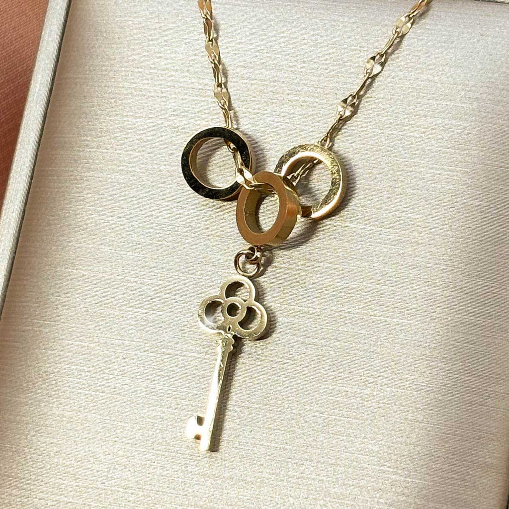 Goldfarbene Damen-Halskette aus Edelstahl im Y-Design mit drei ineinandergreifenden Ringen und einem filigranen Schlüssel-Anhänger, Produktfoto