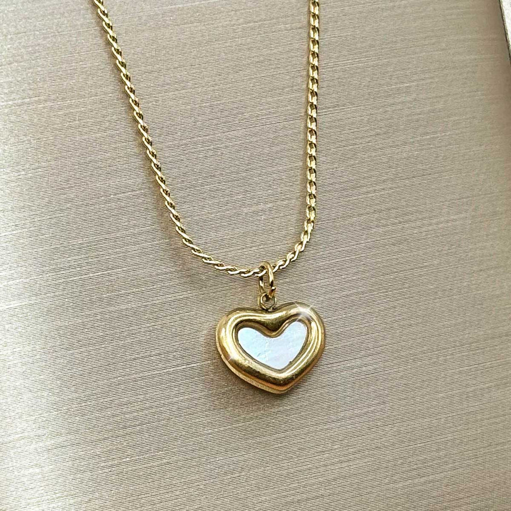 Goldfarbene Edelstahl-Halskette für Damen mit einem bauchigen Herz-Anhänger samt hell schimmerndem Inlay im Zentrum, Produktbild.