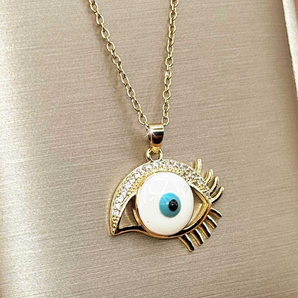 Goldfarbene Edelstahl-Halskette für Damen mit einem auffälligen Auge-Anhänger im Nazar-Design mit langen Wimpern und hellem Inlay, Studioaufnahme.