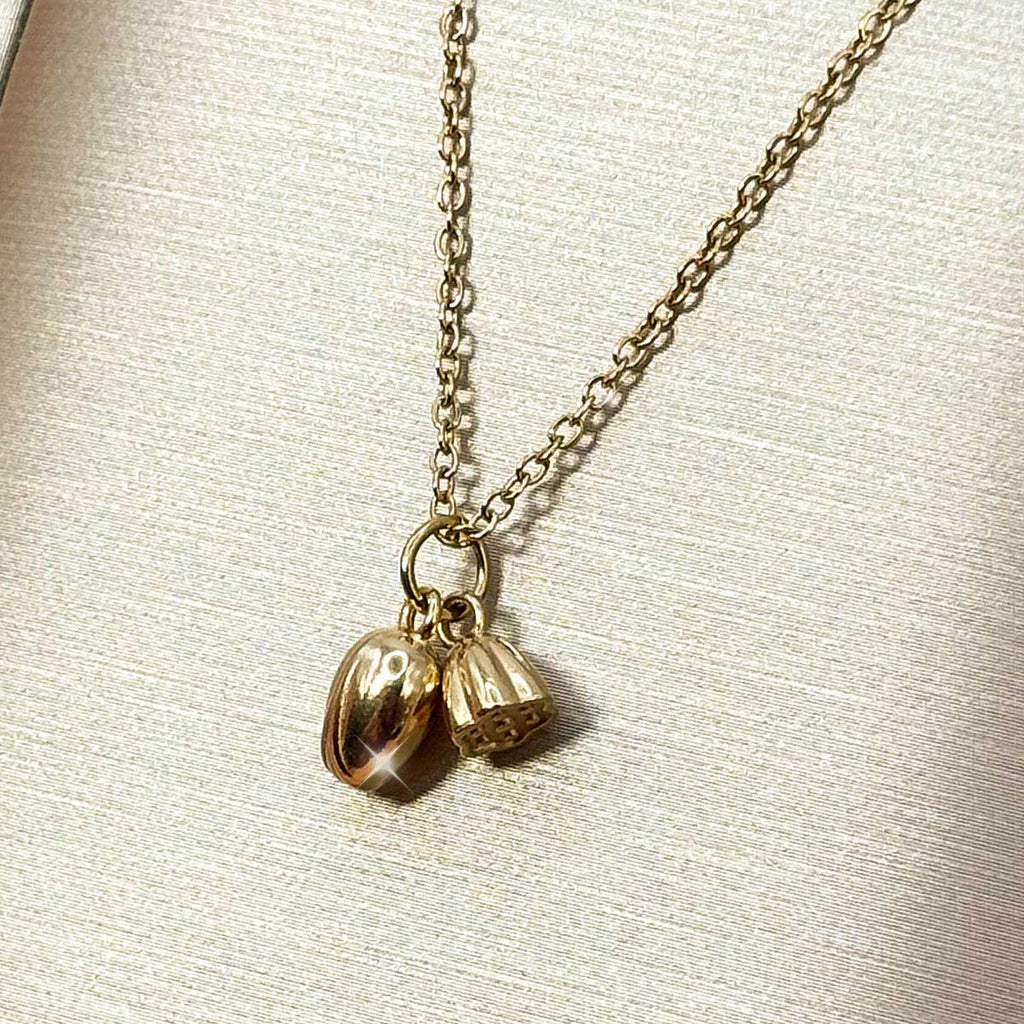 Goldfarbene Damen-Halskette aus Edelstahl mit zwei kleinen, hängenden Anhängern in Form von zarten Lotus- oder Blütenknospen, Produktbild.