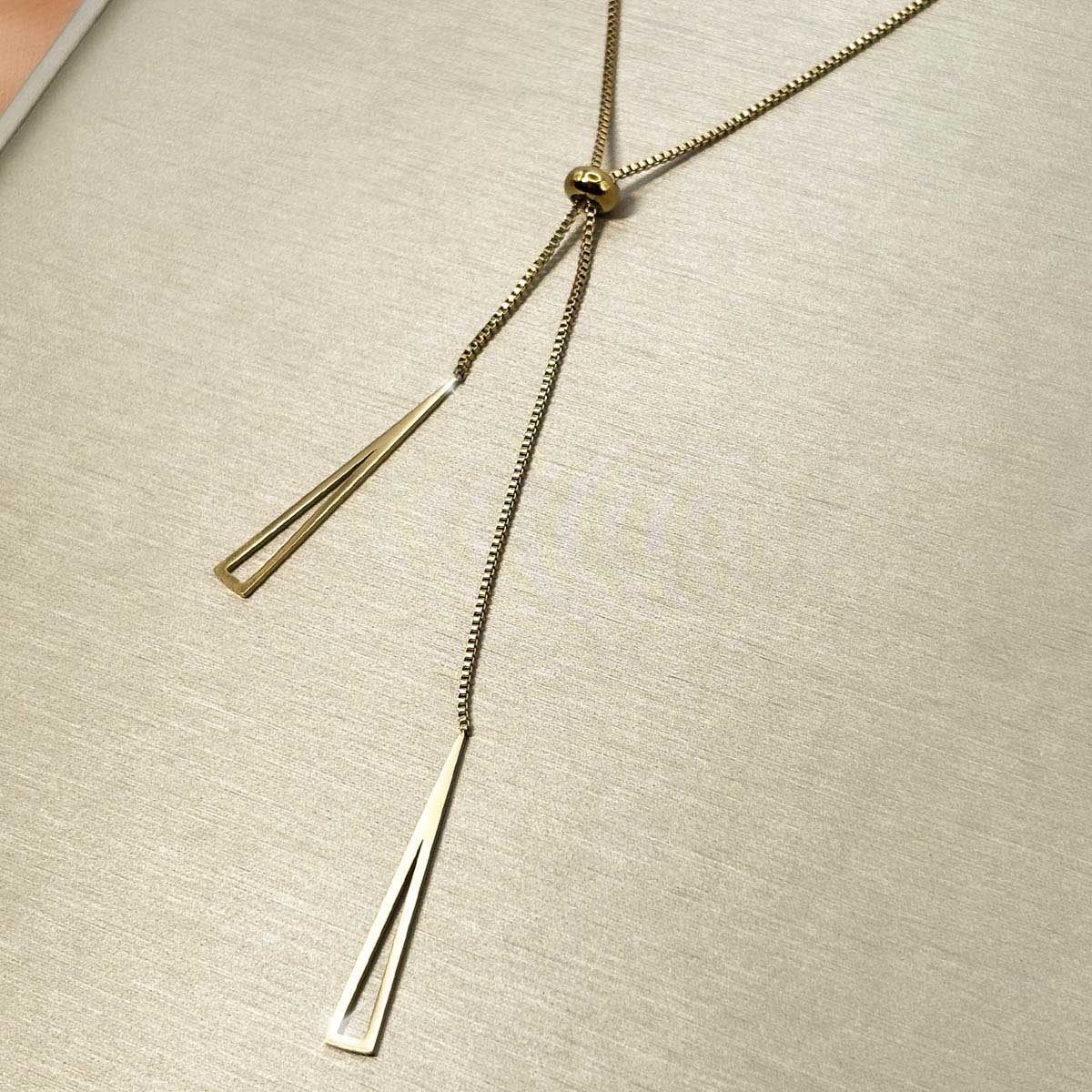 Goldfarbene Damen-Halskette aus Edelstahl im minimalistischen Y-Design mit verstellbarer Perle und zwei hängenden, geometrischen Dreiecks-Elementen, Nahaufnahme.