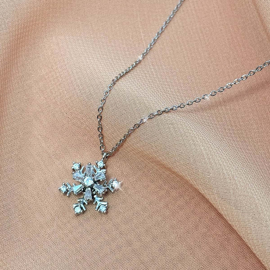 Silberfarbene Halskette mit filigranem Schneeflocken-Anhänger aus funkelnden Zirkonia-Steinen, seitliche Ansicht