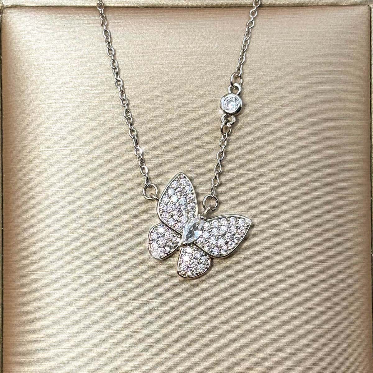 Filigrane silberfarbene Kette mit elegantem, voll besetztem Zirkonia-Schmetterlings-Anhänger, Vorderansicht.