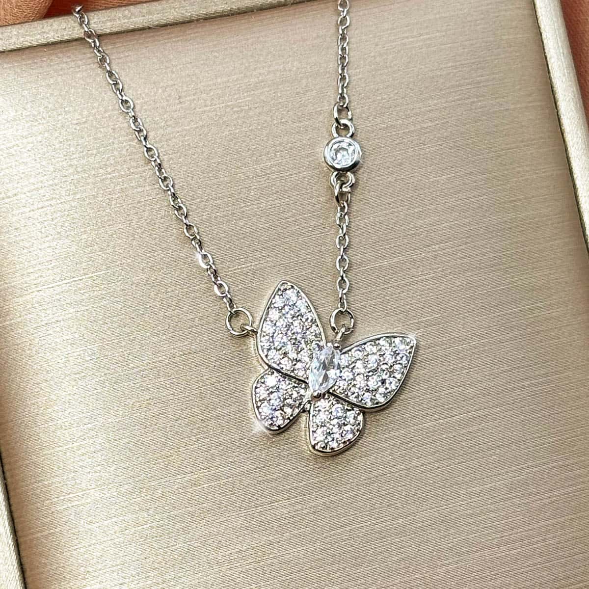 Filigrane silberfarbene Kette mit elegantem, voll besetztem Zirkonia-Schmetterlings-Anhänger, Nahaufnahme.