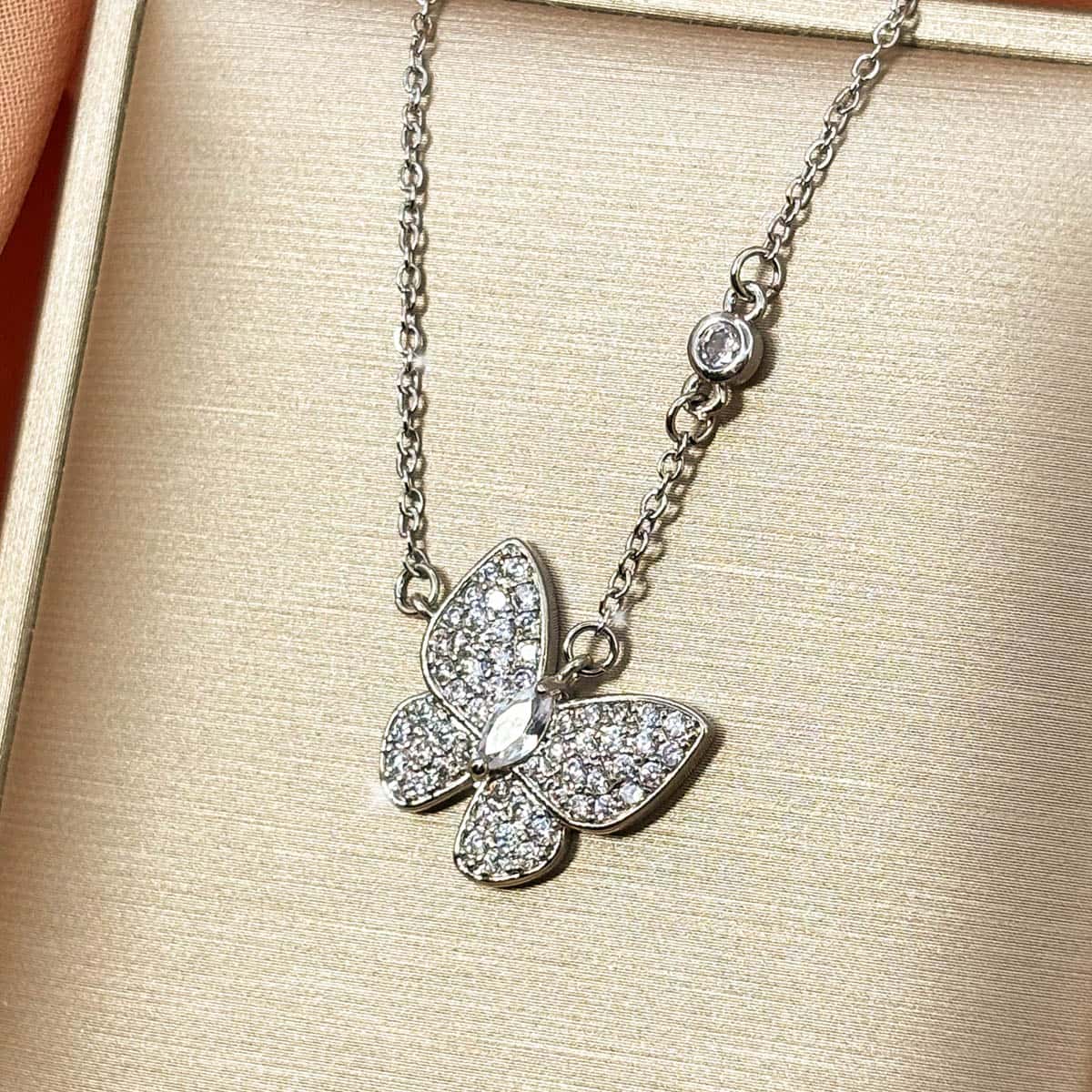 Filigrane silberfarbene Kette mit elegantem, voll besetztem Zirkonia-Schmetterlings-Anhänger, Nahaufnahme von links.