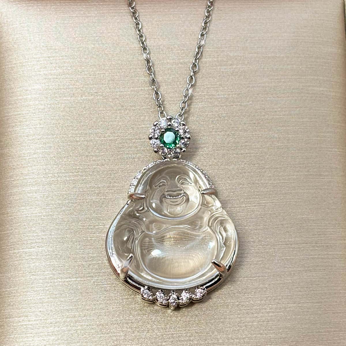 Silberfarbene Halskette mit lachendem Buddha-Anhänger und einem kleinen, grünen Zirkonia-Akzent, Vorderansicht.