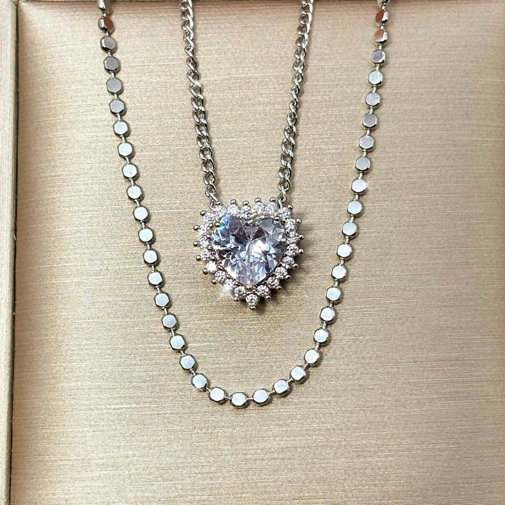 Silberfarbene Halskette mit einem großen Zirkonia-Stein in Herzform und einer Layering Kette, Nahaufnahme