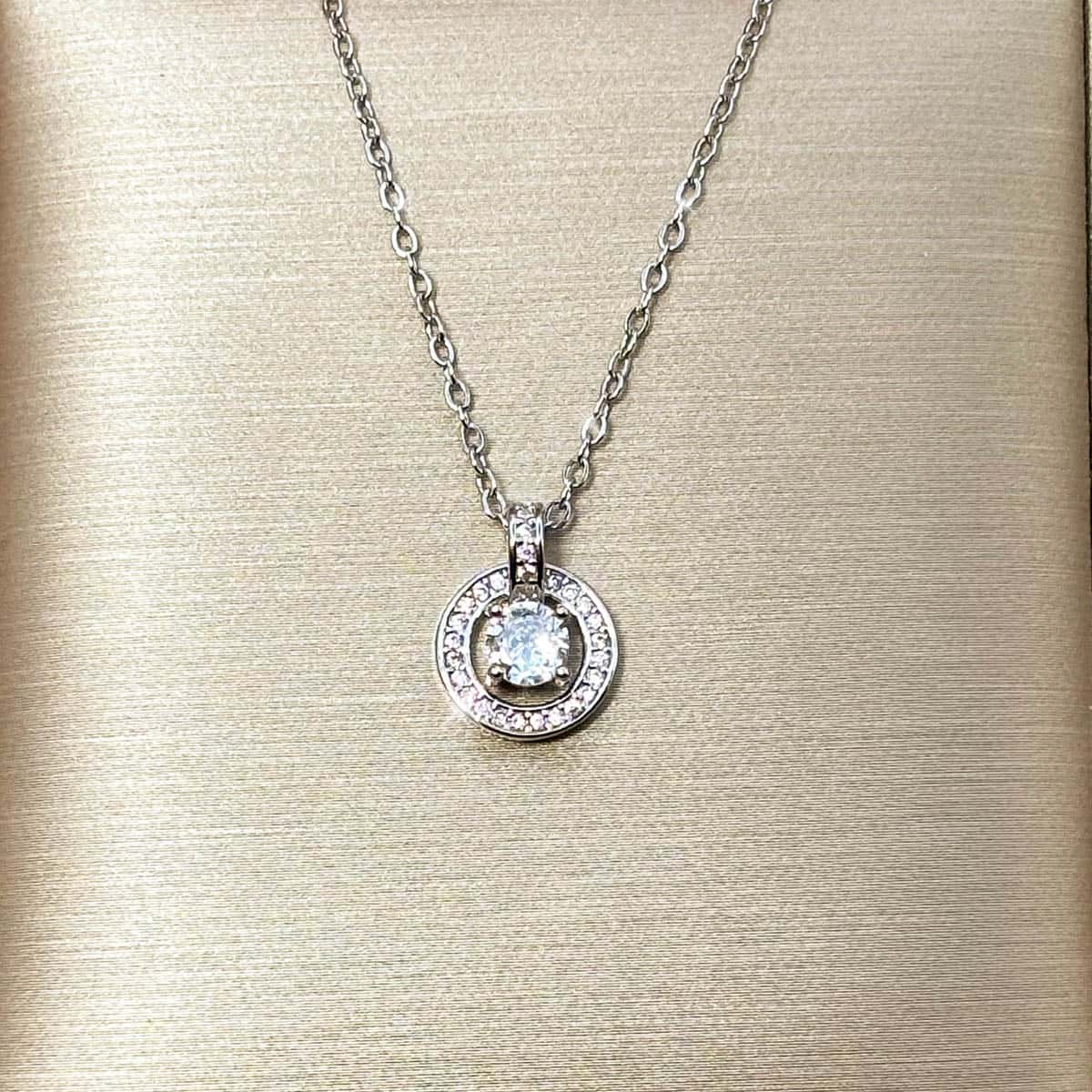 Silberfarbene Halskette mit rundem Anhänger und einem zentralen Zirkonia-Stein, Nahaufnahme