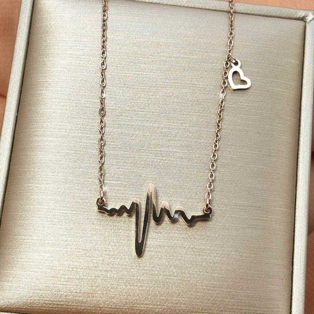 Rosegoldfarbene Edelstahl-Halskette für Damen mit einem integrierten Herzfrequenz-Motiv und einem kleinen Herz-Charm, Produktfoto