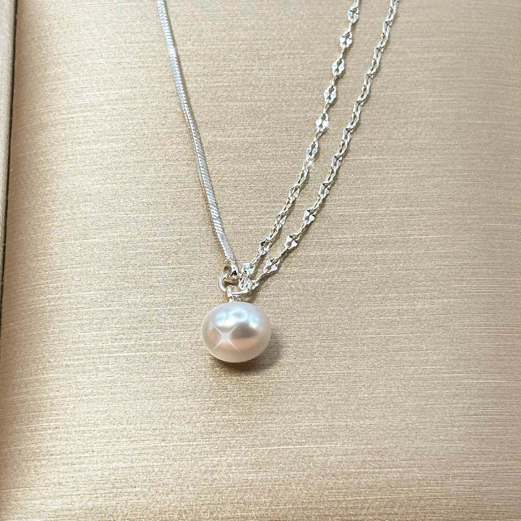 Zweireihige silberfarbene Halskette im Layering-Look mit einer hängenden, weißen Perle, Detail-Aufnahme Vorderansicht