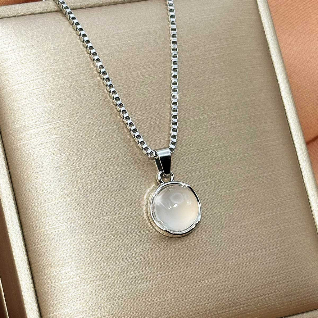 Silberfarbene Damen-Halskette aus Edelstahl mit einem runden, zart schimmernden Anhänger in Opal-Optik, Produtkfoto