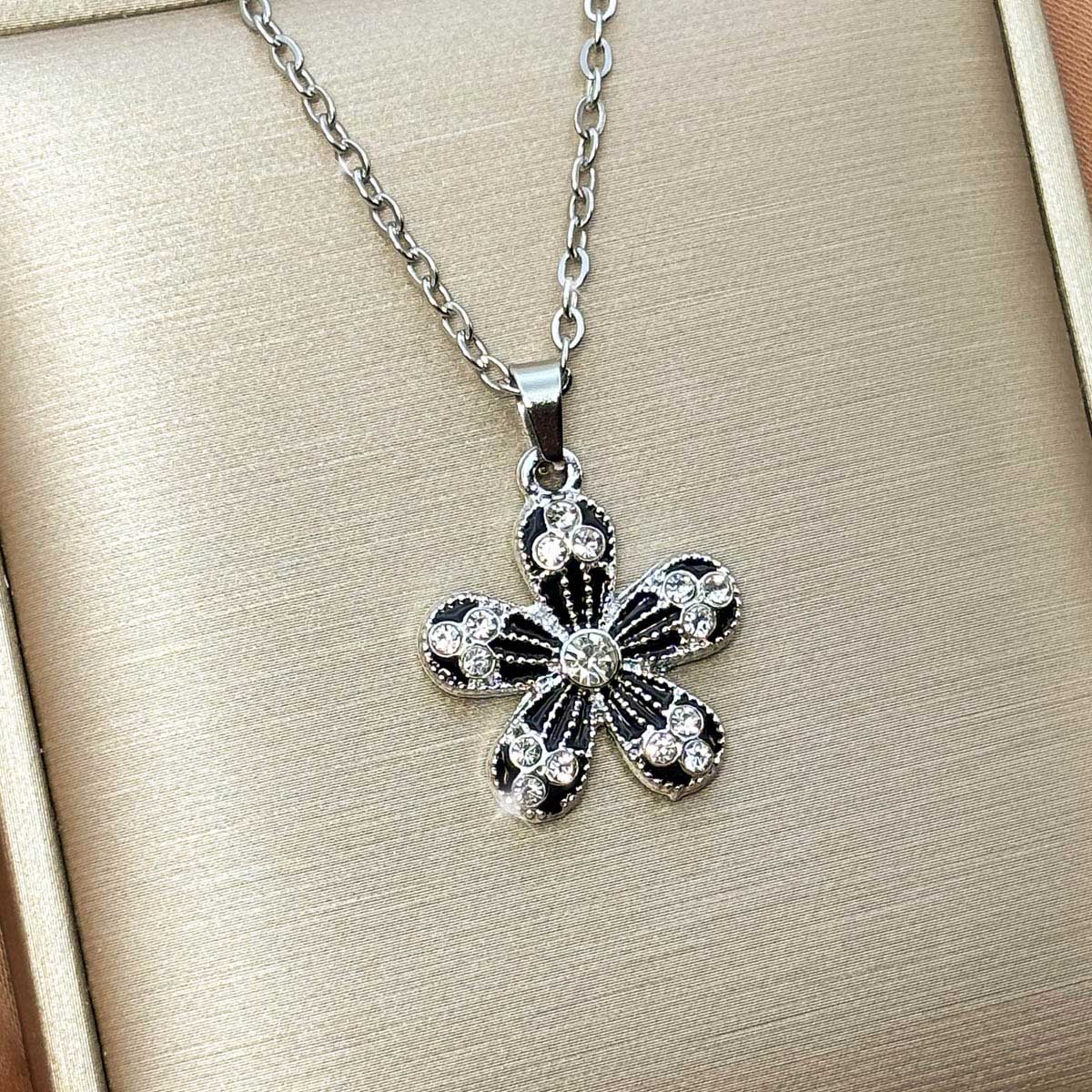 ilberfarbene Damen-Halskette aus Edelstahl mit einem Blumen-Anhänger aus schwarzen Elementen und Zirkonia-Besatz, Produktfoto