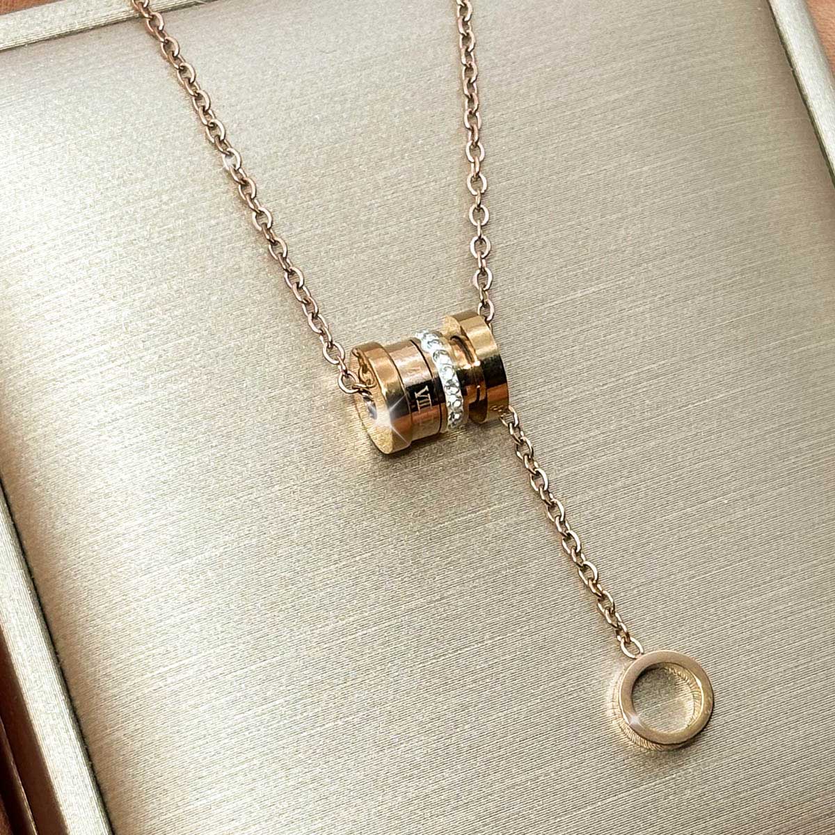 Goldfarbene Damen-Halskette aus Edelstahl im Y-Design mit zirkoniabesetztem Zylinder-Element und kleinem Ring-Charm, Produktfoto.