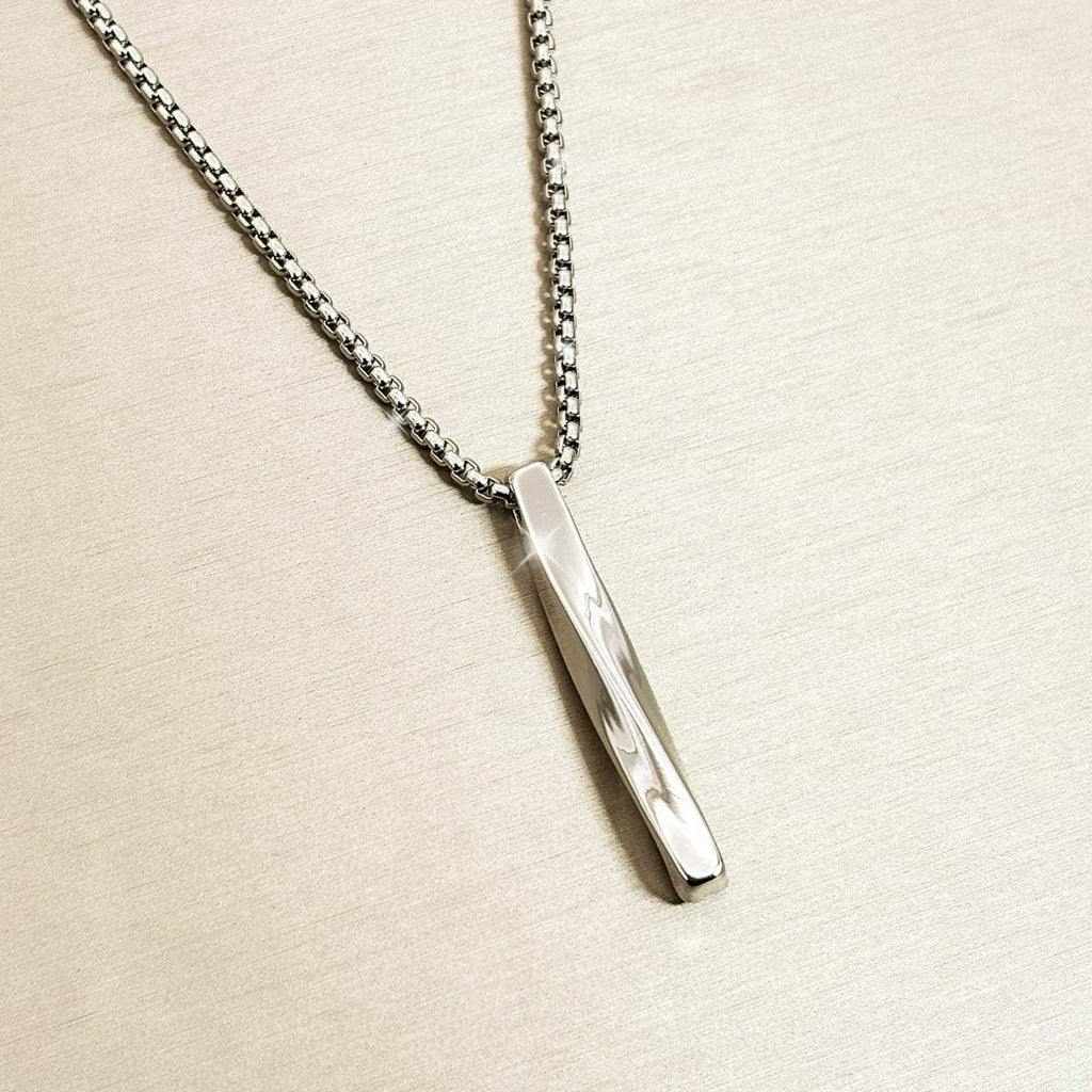 Silberfarbene Herren-Halskette mit schlichtem, gedrehtem Stab-Anhänger aus Edelstahl, Produktfoto von links.