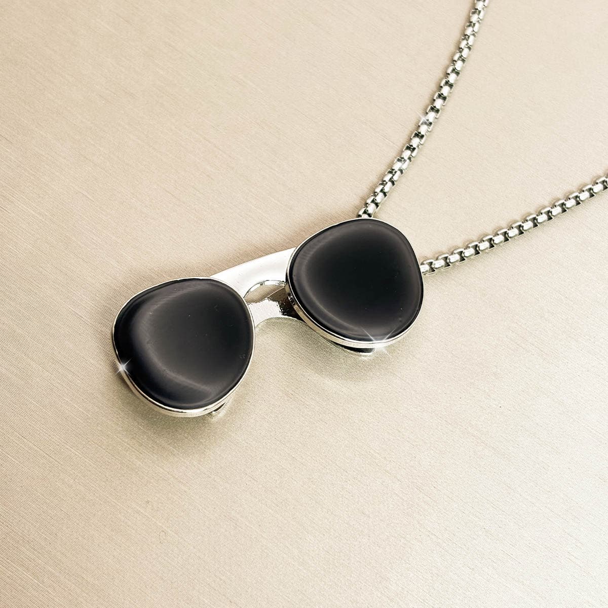 Kreative Herren-Kette aus Edelstahl in Silber mit schwarzem Sonnenbrillen-Anhänger, Detail-Aufnahme von links