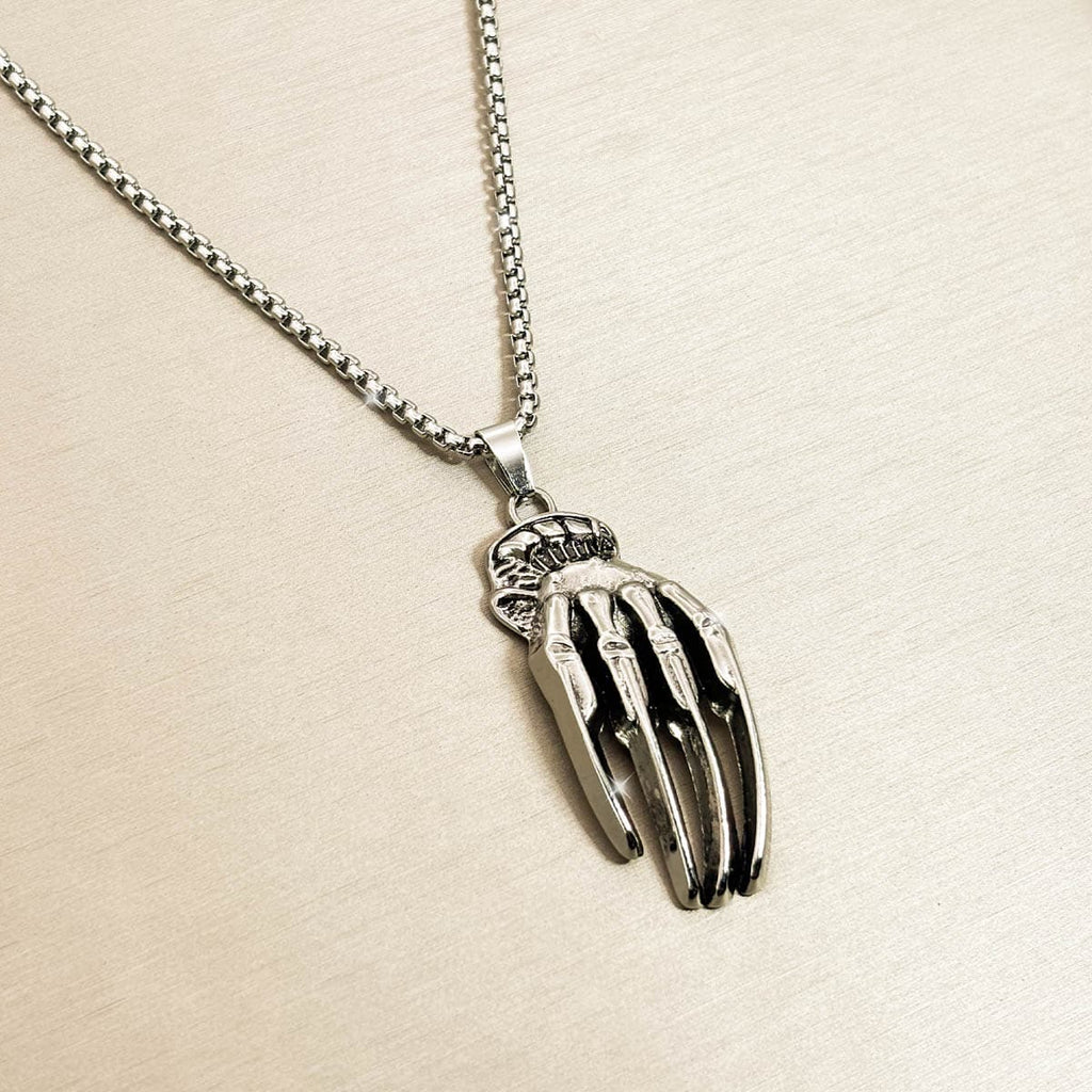 Silberfarbene Edelstahl-Herrenkette mit detailreichem Skeletthand-Anhänger, Produktfoto in Nahaufnahme