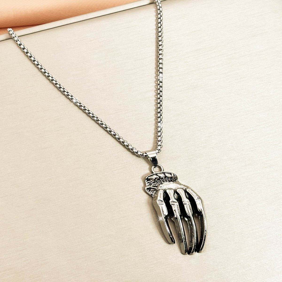 Silberfarbene Edelstahl-Herrenkette mit detailreichem Skeletthand-Anhänger, Produktfoto von links