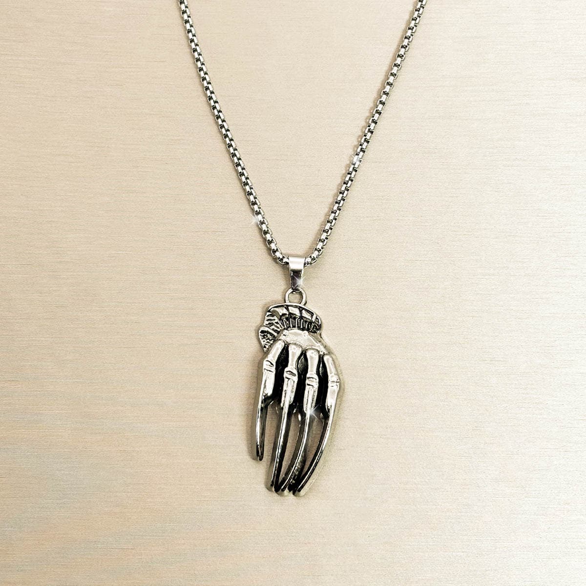 Silberfarbene Edelstahl-Herrenkette mit detailreichem Skeletthand-Anhänger, Produktfoto.